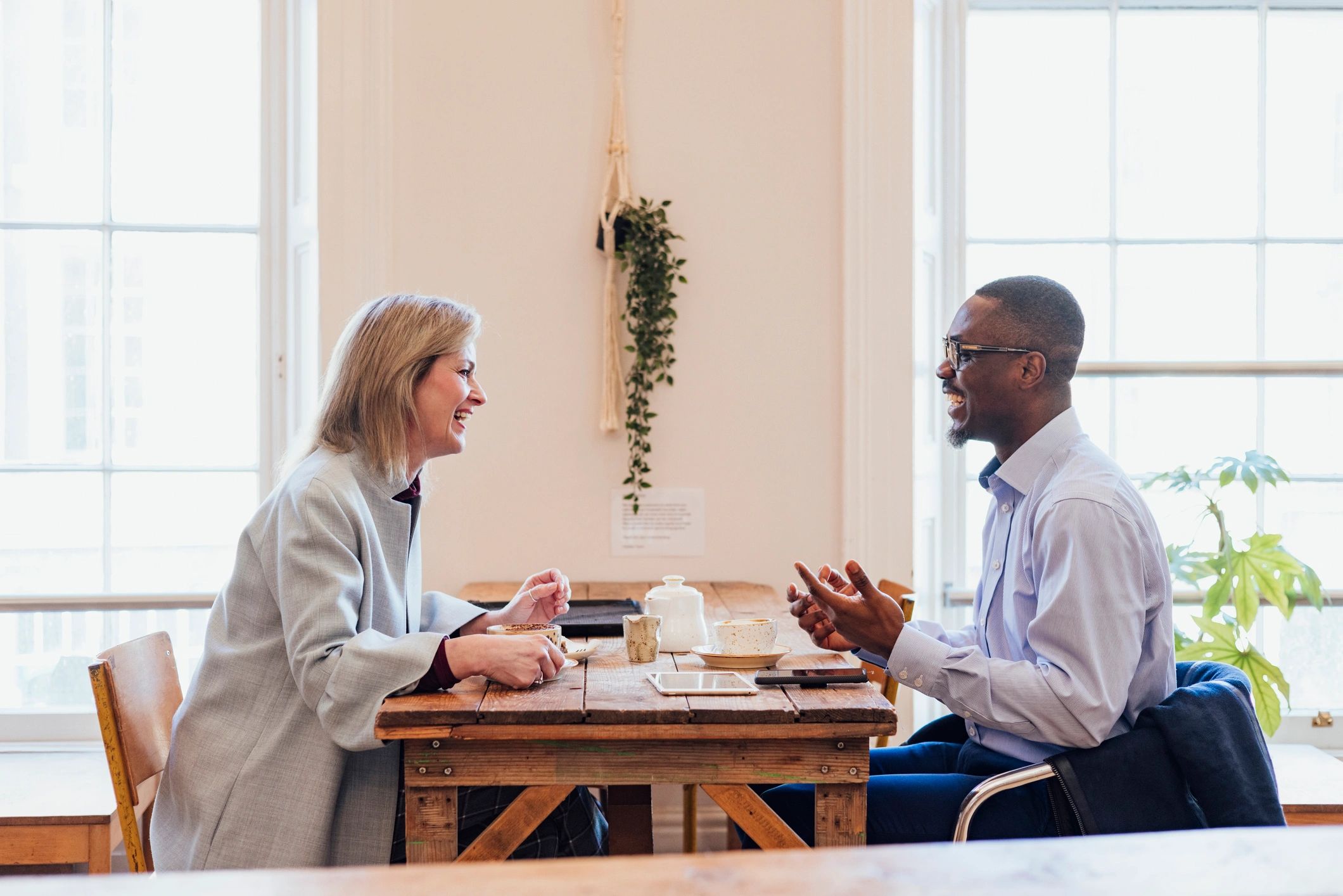 Two adults in conversation at a table during a coaching session